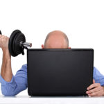 Businessman using weights at his desk